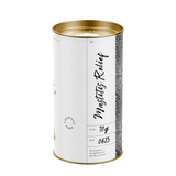 A cylindrical metal tin candle with a white label and gold-toned top and bottom rims. The label reads 'Mastitis Relief' in black script and includes product details such as 'Chemical Free' and '70g'.