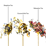 Three labeled dried tea blends on gold spoons against a white background: Sleeptime Tea with blue and yellow flowers, Coconut Mint Tea with green and yellow pieces, and Relaxation Tea with pink and red botanicals.